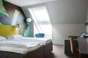 a hotel room with two beds and a window at Comfort Hotel Kristiansand in Kristiansand