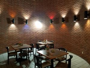 a restaurant with tables and chairs and a brick wall at Apple Tree Inn in Independence