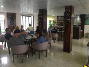 a group of people sitting at tables in a restaurant at Hoang Ngoc Hotel in Dồng Văn