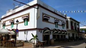 ein weißes Gebäude mit grünen Fenstern an einer Straße in der Unterkunft Hotel Bonilla in La Barca de la Florida