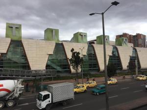 un gran edificio con coches estacionados frente a él en Apto cerca del CC Titan Plaza 102, en Bogotá
