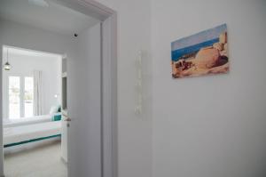 
a white wall with a picture of a dog on it at Hotel Delfini in Mylopotas
