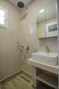 a bathroom with a sink and a shower at Hotel Delfini in Mylopotas