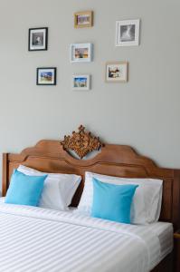 um quarto com 2 camas com almofadas azuis e brancas em Golf Inn Resort em Samut Songkhram