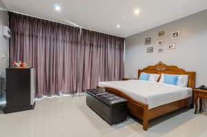 um quarto com uma cama grande e uma janela em Golf Inn Resort em Samut Songkhram