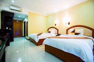 Habitación de hotel con 2 camas y baño en Classy Hotel en Battambang