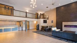 a lobby with a staircase and a living room at Best Western Plus Flint Airport Inn & Suites in Flint