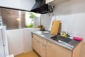 a small kitchen with a sink and a counter top at Bijou Suites Nagomi in Osaka