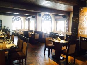 a dining room with tables and chairs and windows at Hotel Ramanashree Richmond in Bangalore