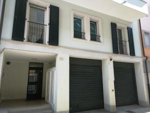 ein Gebäude mit zwei Garagentüren und zwei Fenstern in der Unterkunft Grado Exclusive Apartment in Grado