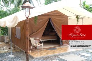 a tent with a chair and a red sign at Kama Siri Koh Kood in Ko Kood