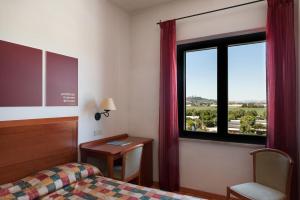 ポルト・レカナーティにあるHotel Brigantino Non Distaのベッドと窓が備わるホテルルーム