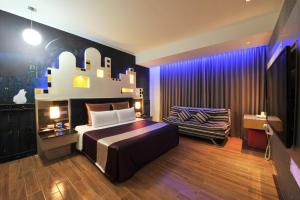 - une chambre avec un grand lit et une chaise dans l'établissement ZJ Motel, à Hsinchu