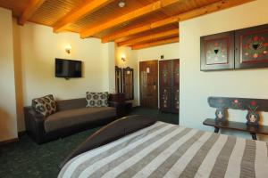 une chambre d'hôtel avec un lit et un canapé dans l'établissement Pension Tempo, à Târgu-Mureş