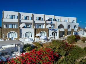 a large white building with flowers in front of it at Vardia Bay Studios in Karavostasi