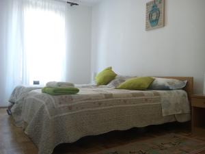 una camera da letto con un letto con cuscini verdi e una finestra di Apartment Irene a Pola (Pula)