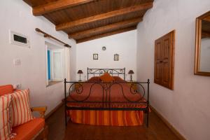 a bedroom with a bed and a chair in a room at Original Villa Petros in Symi