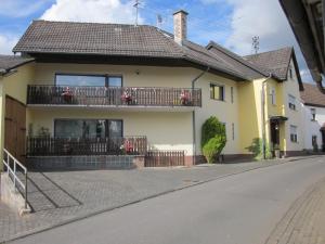 Casa amarilla con balcón en una calle en Ferienwohnung Maria, en Wimbach