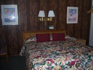 a bedroom with a bed with red pillows at Shasta Dam Motel in Shasta Lake