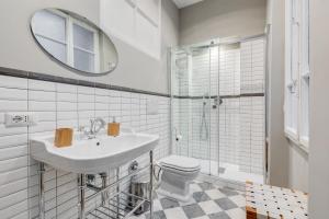 łazienka z umywalką, toaletą i lustrem w obiekcie Monti Colosseum apartment w Rzymie +18 zdjęć