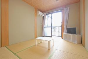 salon ze stołem i oknem w obiekcie Minshuku Tsurinoie w mieście Tsushima