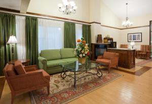 salon z zieloną kanapą i krzesłami w obiekcie Country Inn & Suites by Radisson, Coon Rapids, MN w mieście Coon Rapids