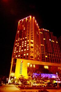 wysoki budynek z oświetleniem w nocy w obiekcie Weihai Haiyue Jianguo Hotel w mieście Weihai