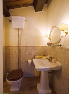 ein Badezimmer mit Toilette, Waschbecken und Spiegel in der Unterkunft La Corte De' Vasari in Bevagna