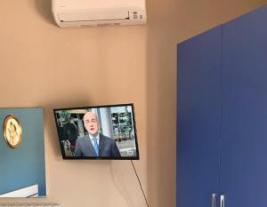 TV de pantalla plana colgada en la pared en SoleLuna B&B, en Rende