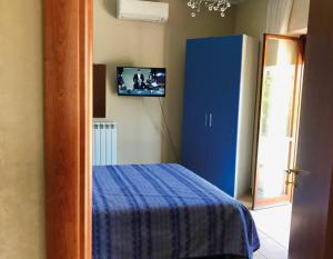 una camera con letto blu e TV a parete di SoleLuna B&B a Rende