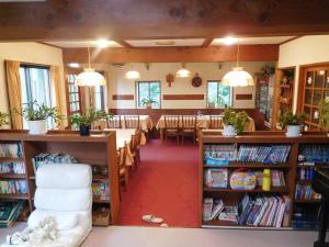 biblioteca con mesa, sillas y libros en Madarao Elm Pension en Iiyama