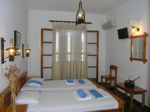 sypialnia z 2 łóżkami i oknem w obiekcie Pension Chanioti w mieście Parikia