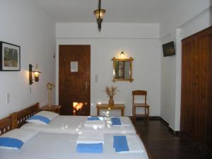 a bedroom with a large white bed with blue pillows at Pension Chanioti in Parikia