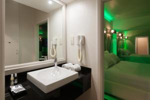 y baño con lavabo blanco y espejo. en Motel Tropicana, en Vila Nova de Gaia