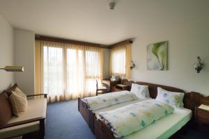 um quarto com uma cama, um sofá e uma janela em Hotel Bahnhof em Giswil