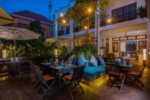 a restaurant with tables and chairs and a couch at Apsara Centrepole Hotel in Siem Reap