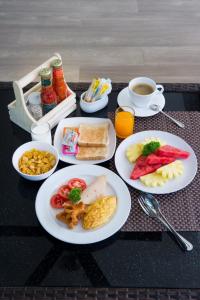 una mesa con platos de comida y una taza de café en Pumeria Resort Phuket - SHA Plus, en Bang Tao Beach