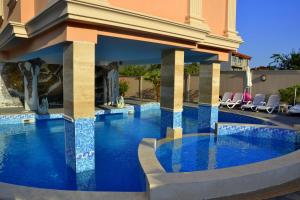 a swimming pool in a resort with chairs around it at Sirena Palace Family Hotel in Obzor