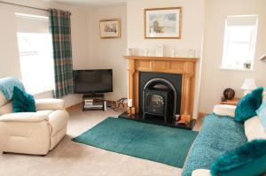 a living room with a fireplace and a tv at Roe Valley Cottage - LA Spa Hot Tub in Limavady
