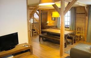 LʼHuezにあるOdalys Chalet Alpenvueのリビングルーム(木製テーブル、テレビ付)
