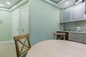 a kitchen with a wooden table and two chairs at Feelathome Apartments - Nevsky in Saint Petersburg