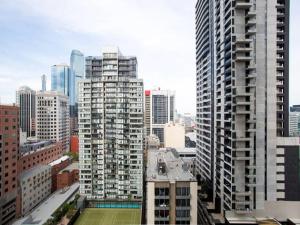 a city skyline with tall buildings and a tennis court at UWS Madison Melbourne CBD Apartment in Melbourne