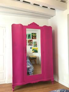 a pink cabinet with a mirror in a room at Apartamentos La Selva in Cádiz
