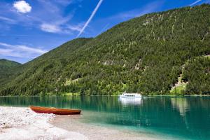 a boat on a lake in front of a mountain at Haus Kalt in Weissensee