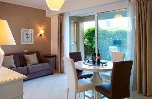 タオルミーナにあるTaormina Villa Oasis Residenceのリビングルーム(テーブル、椅子、ソファ付)