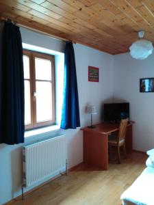 Schlafzimmer mit einem Schreibtisch und einem Fenster mit blauen Vorhängen in der Unterkunft Hotel Sonnenhof in Litschau