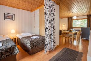 a hotel room with two beds and a dining room at Poukama in Porvoo