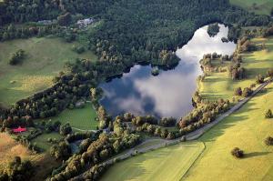 an aerial view of a lake in a field at Loch Monzievaird Chalets in Crieff
