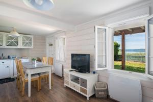 a kitchen and dining room with a table and a television at Fleur d'eau in Montperreux
