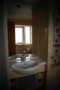 baño con lavabo blanco y ventana en Marie's Bed and Breakfast, en Coolock